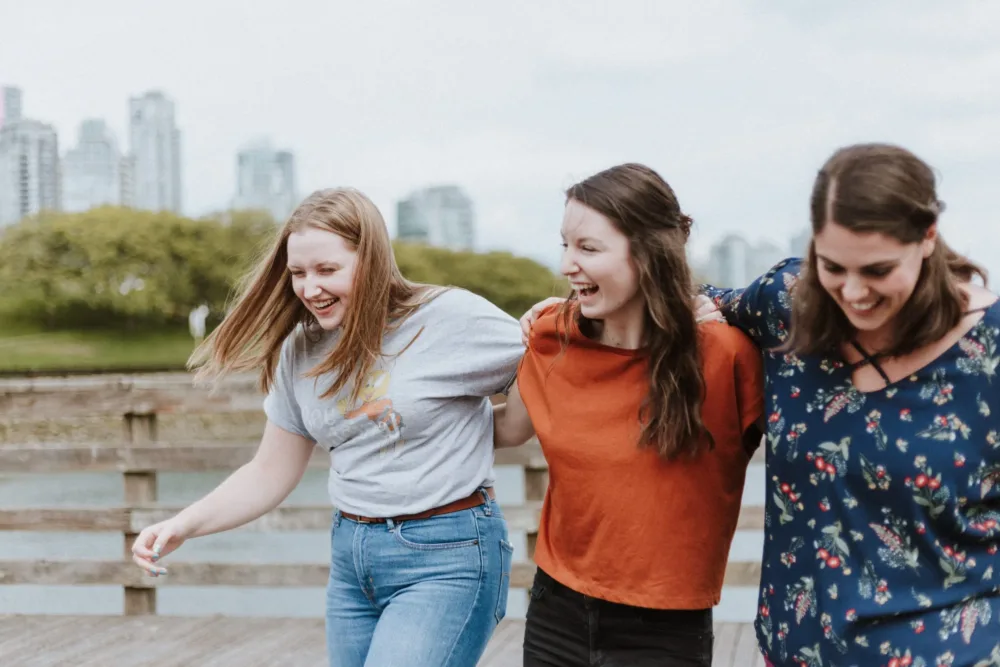 Three friends laughing with a city view
